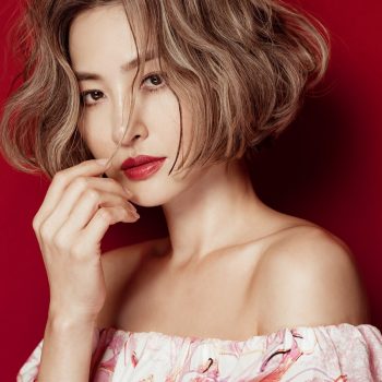 A woman with short hair and bold red lips, exuding confidence and style.